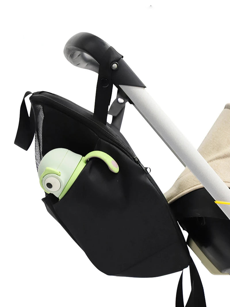 Compartiment lateral profond accueillant la gourde de bebe accroche par sa dragonne le long de la poussette.