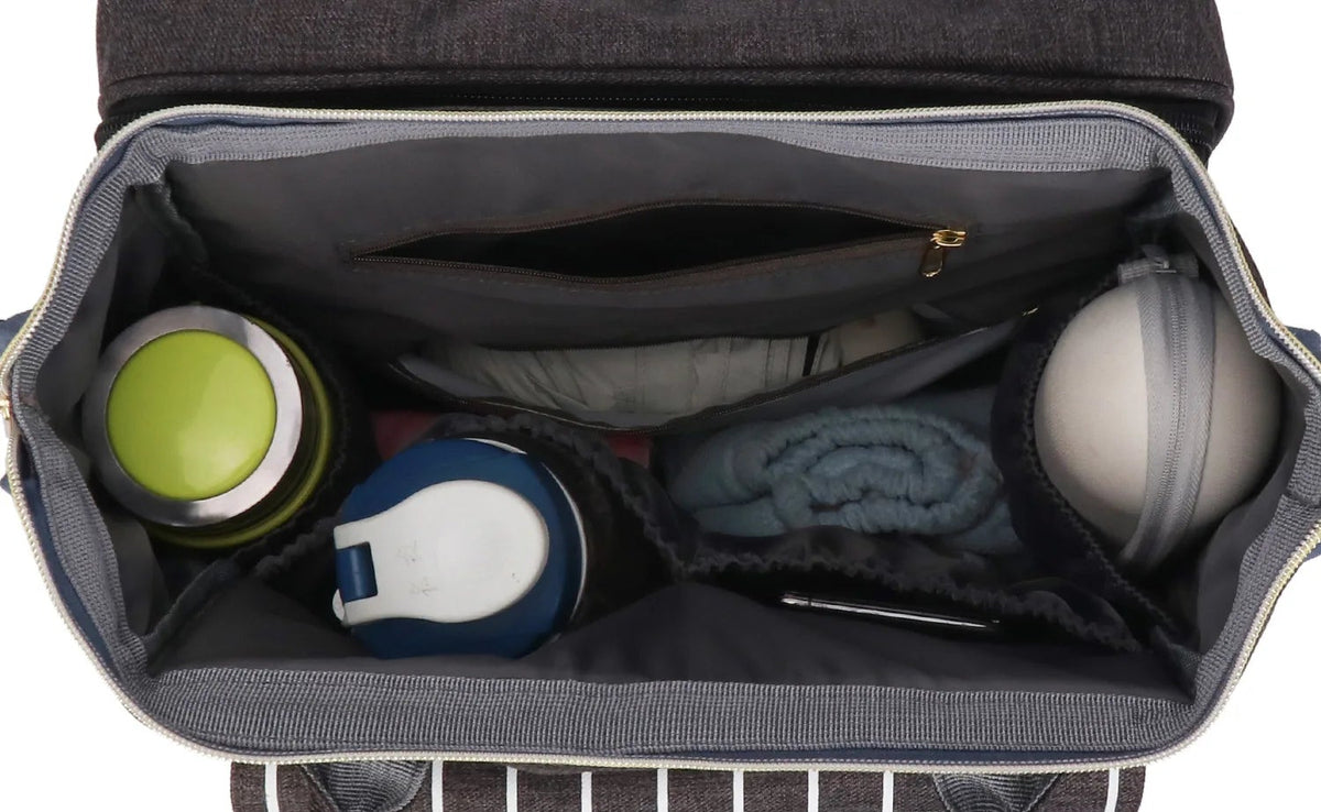 Interieur spacieux du sac a langer avec un grand compartiment et six poches organisant biberons, couches, vetements et serviettes.