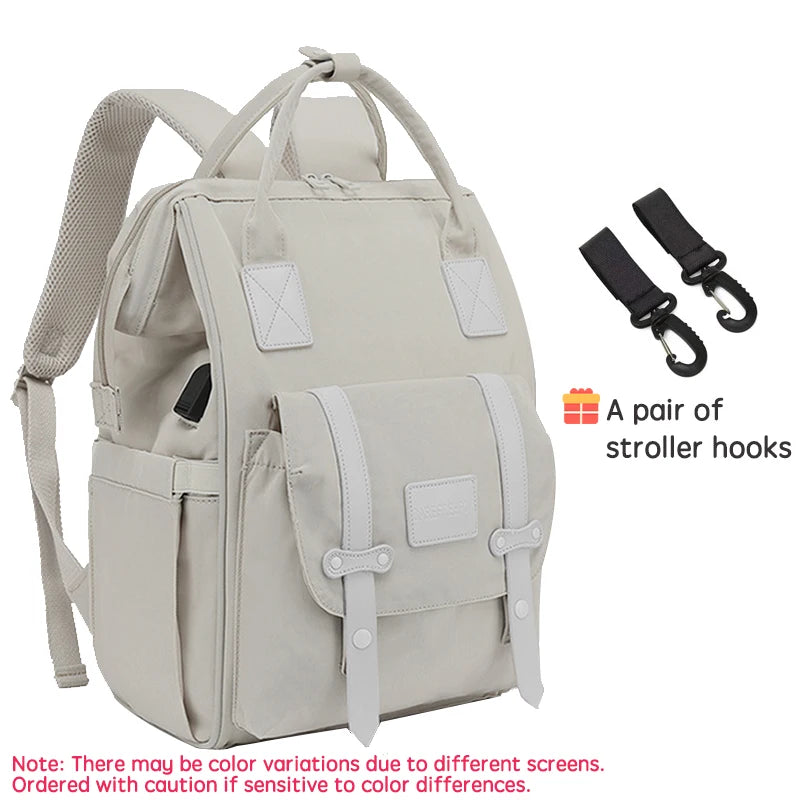 Sac a langer sac a dos beige livre avec une paire de crochets pour fixer facilement le sac a la poussette lors des sorties.