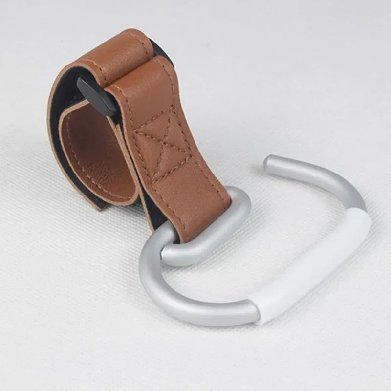 Attache poussette en cuir marron cognac, finition couture premium pour un look raffine sur toute promenade.