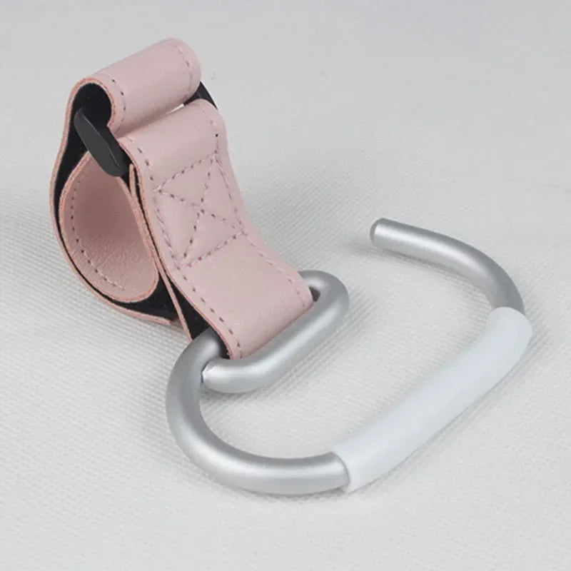 Attache poussette rose poudre au design doux, un accessoire tendance pour liberer vos mains en balade.