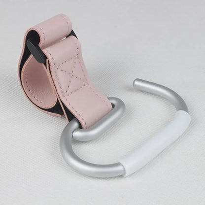 Attache poussette rose poudre au design doux, un accessoire tendance pour liberer vos mains en balade.