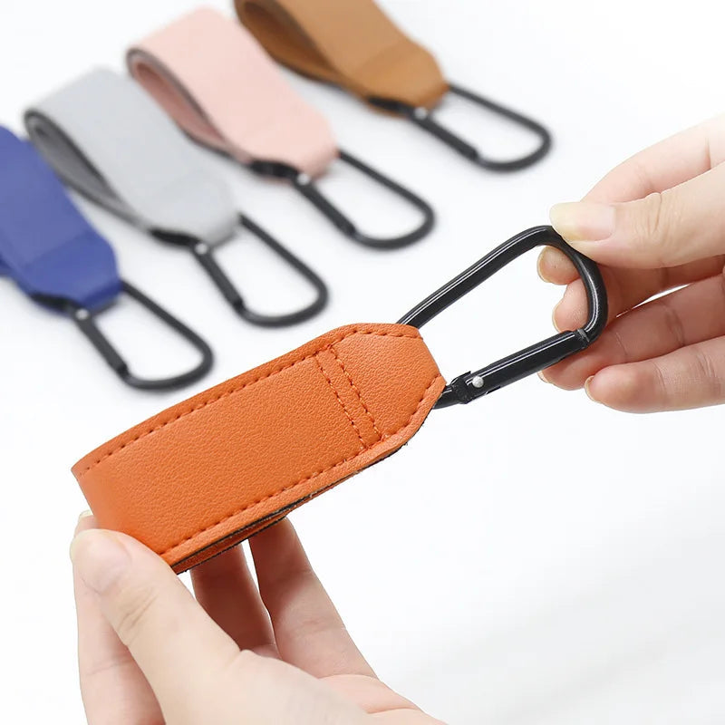 Mousqueton metallique manipule a une main pour accrocher ou detacher rapidement le sac en promenade.