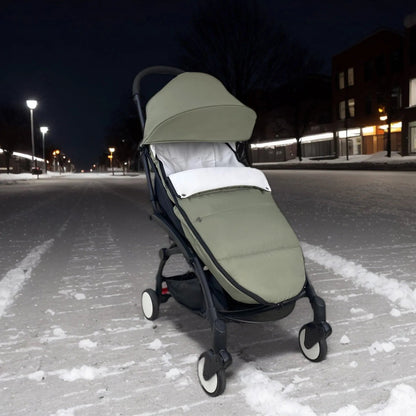 Chancelier bebe utilise en pleine ville enneigee la nuit, protegeant l'enfant du froid hivernal lors des sorties.