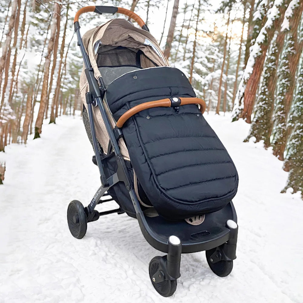 La chanceliere isolante en action sur un chemin enneige en foret, prouvant sa capacite a garder bebe bien au chaud par grand froid.