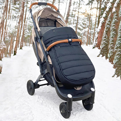 La chanceliere isolante en action sur un chemin enneige en foret, prouvant sa capacite a garder bebe bien au chaud par grand froid.