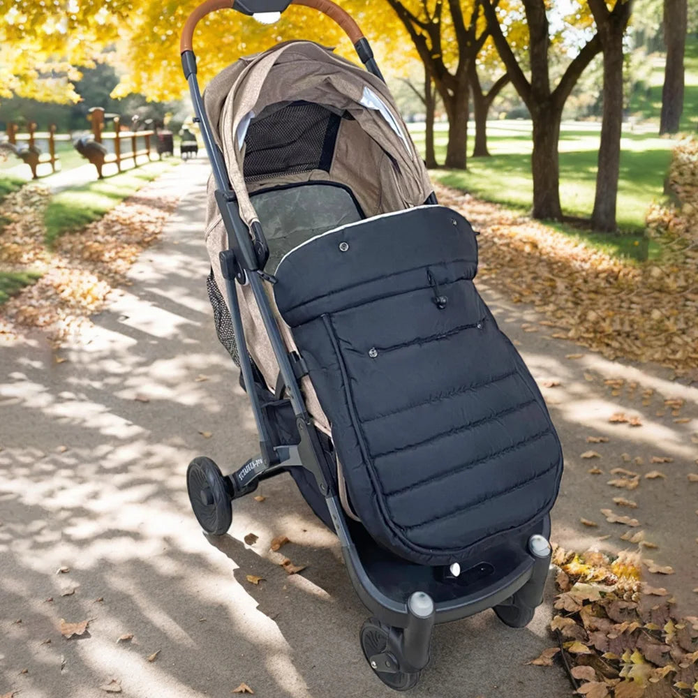 Chanceliere adaptee sur la poussette lors d'une promenade d'automne dans un parc, ideale pour les temperatures fraiches de mi-saison.