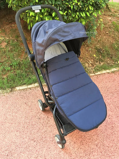 Chanceliere bleue installee sur une poussette lors d'une promenade en exterieur pour garder bebe au chaud.