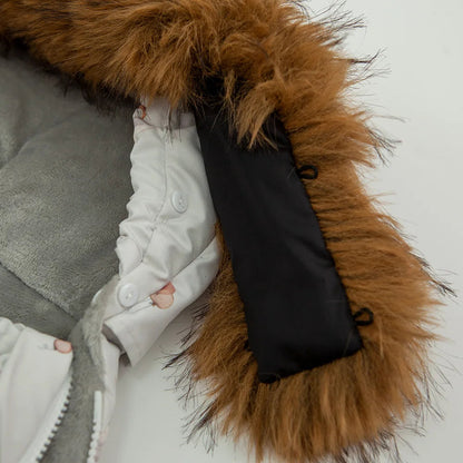 Detail de la capuche en fausse fourrure attachee par boutons, entierement detachable pour un nettoyage facile.