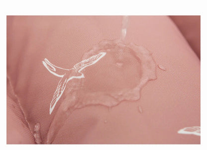 Goutte d'eau perlant sur le tissu de la chanceliere, preuve de son revetement deperlant qui garde bebe au sec sous la pluie.