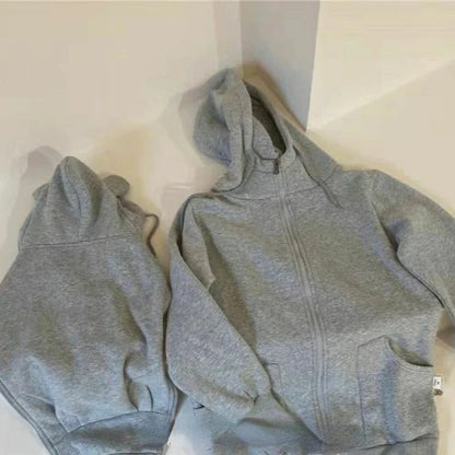 Manteau de portage gris avec double capuche pour maman et bebe, presente a plat pour montrer la coupe evolutive.