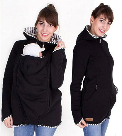Le manteau de portage noir se transforme en veste classique une fois le panneau bebe retire, ideal pour un usage toute l'annee.