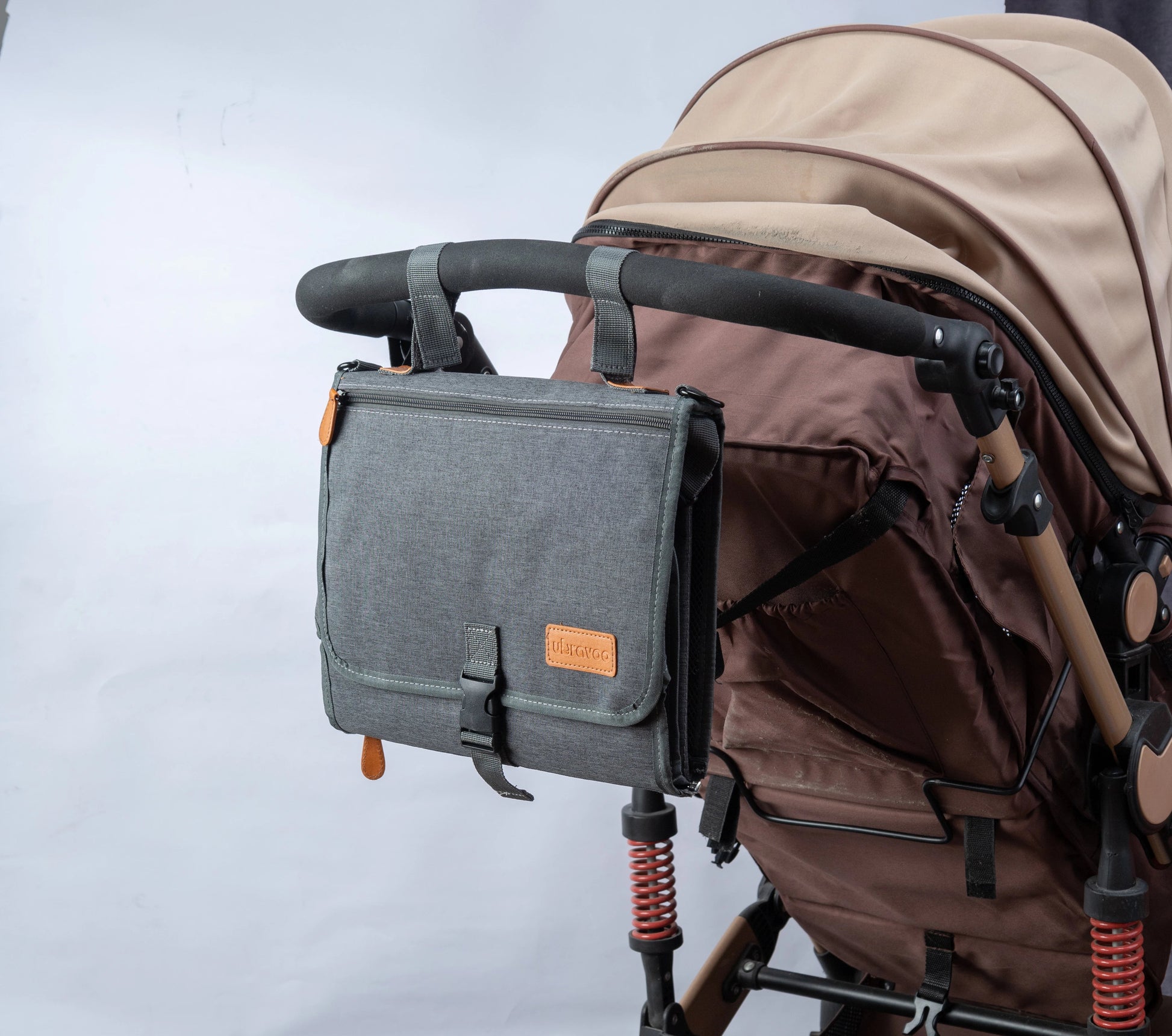 Matelas nomade gris accroche au guidon de la poussette pour garder le necessaire de change a portee de main en promenade