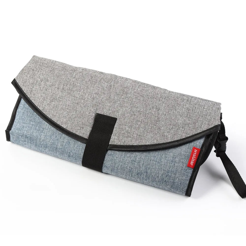 Matelas a langer nomade en coloris gris et bleu denim, discret et elegant pour les parents en balade.