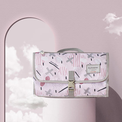 Matelas a langer nomade Sunveno en coloris rose a motifs graphiques, compact et elegant pour les sorties quotidiennes.