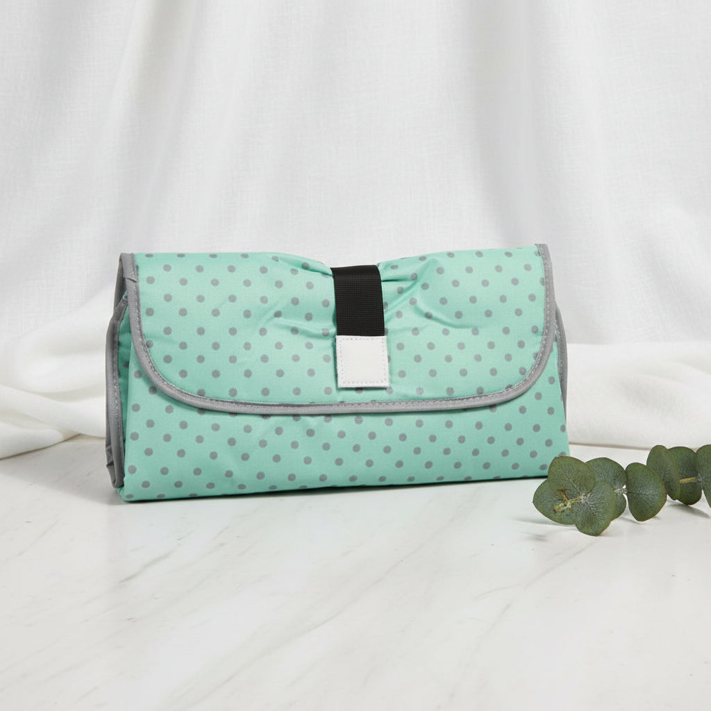Matelas a langer nomade plie en pochette vert menthe a pois, discret et leger pour les sorties avec bebe.