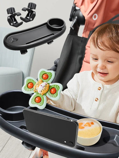 Bebe souriant devant son plateau garni d'un bol de compote et d'un jouet, installe confortablement dans la poussette.