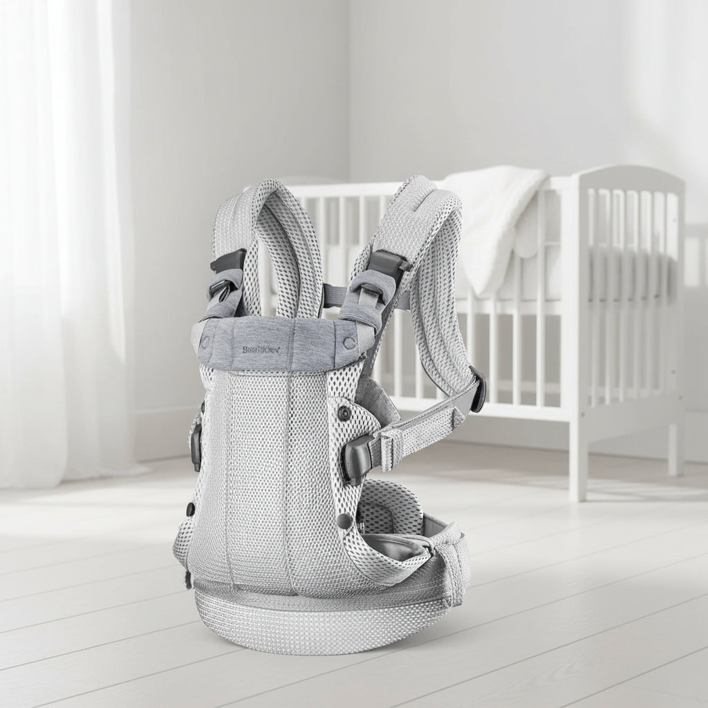 Porte bebe physiologique en maille 3D grise avec bretelles rembourrees et boucles de reglage, ideal pour les journees chaudes.