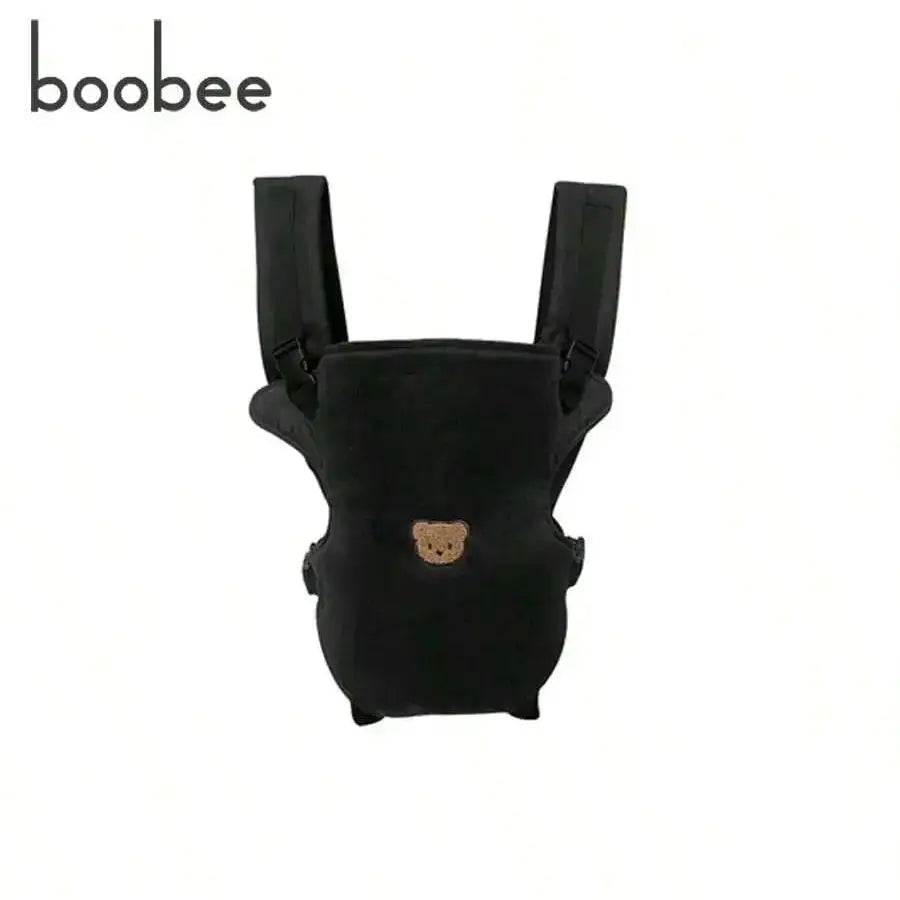 Porte-bebe physiologique noir avec motif ourson brode, vue de face montrant les bretelles rembourrees et l'assise ergonomique.