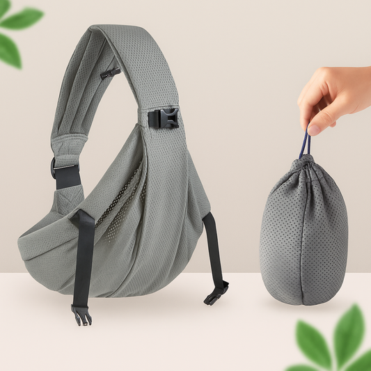 Porte-bebe sling gris presente seul avec son sac de rangement compact tenu a la main, ideal pour le glisser dans un sac a langer.