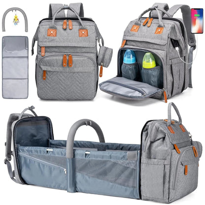 Sac a dos a langer gris avec lit bebe pliable integre, port USB et accessoires inclus pour les parents nomades.