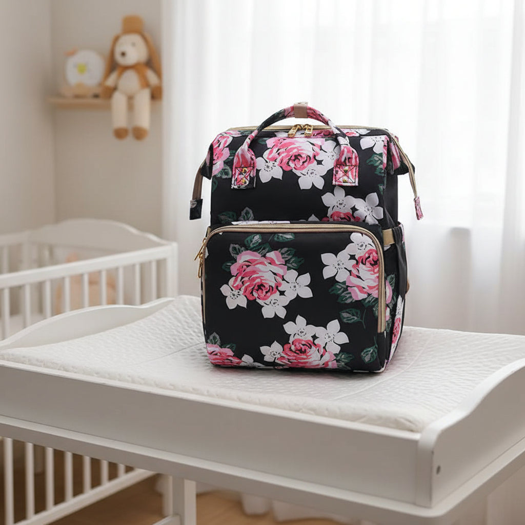 Sac a dos a langer noir a roses roses, coloris chic ideal pour les parents recherchant un accessoire discret et elegant.