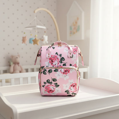Sac a langer rose clair a grandes fleurs vu de face, format compact adapte aux sorties courtes avec bebe.