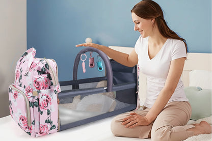 Maman deploie sans montage le lit portable integre au sac, offrant a bebe un couchage stable et ventile n'importe ou.