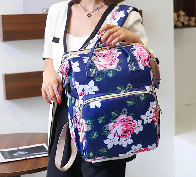 Le sac a langer bleu marine porte au bras montre son allure raffinee pour accompagner les tenues elegantes du quotidien.