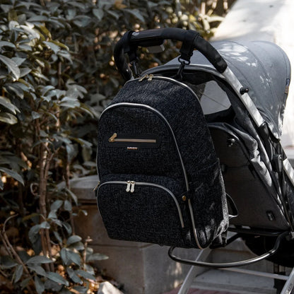 Sac a langer a dos accroche a une poussette lors d'une balade, liberant les mains des parents en promenade avec bebe.