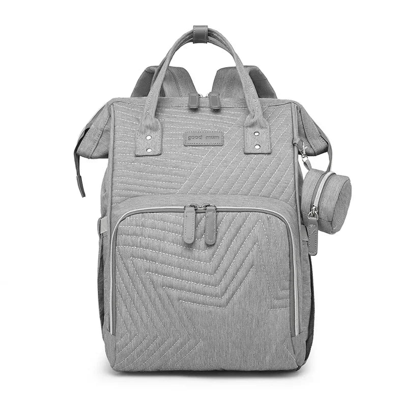 Sac a langer a dos gris clair, coloris neutre qui s'accorde a toutes les tenues des jeunes parents.