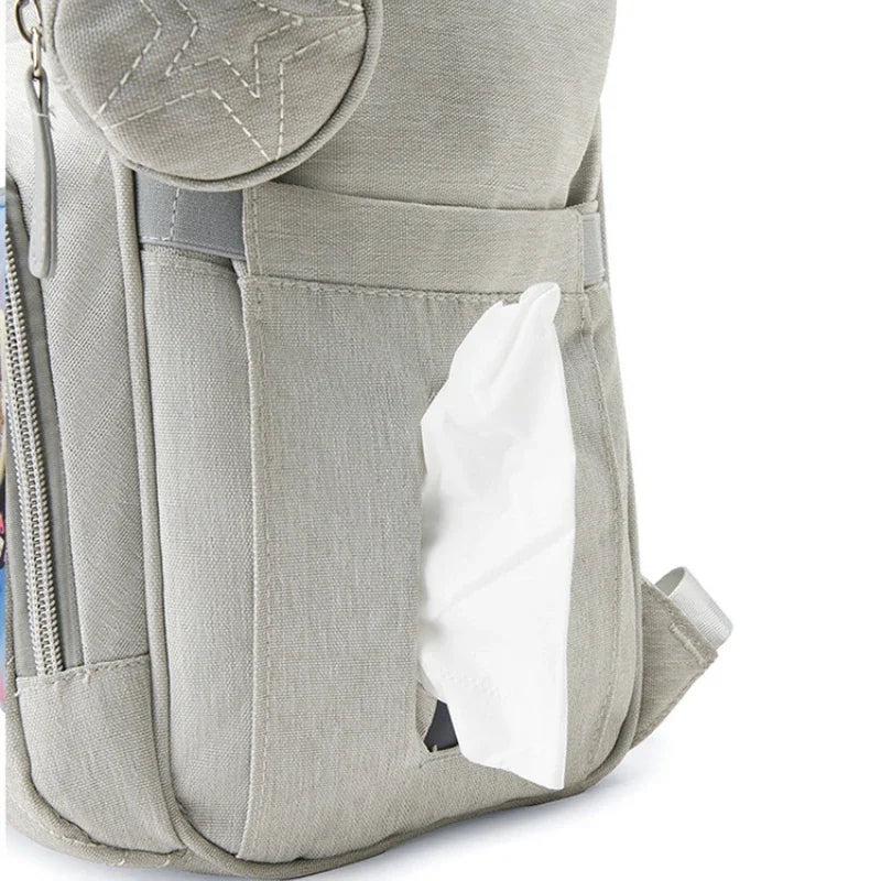 Distributeur de lingettes integre sur le cote du sac pour changer bebe rapidement d'une seule main.