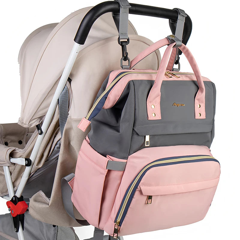 Sac a langer bicolore rose et gris accroche a la poignee d'une poussette pour garder les mains libres en promenade.