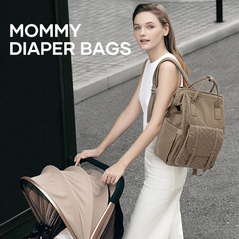 Maman elegante en balade urbaine portant le sac a langer a dos tout en poussant la poussette de bebe, mains libres et style preserve.