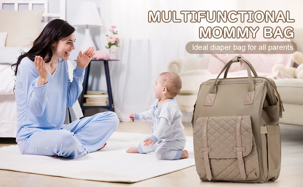 Maman jouant avec son bebe a la maison, le sac a langer multifonction pose a cote comme accessoire indispensable du quotidien des parents.