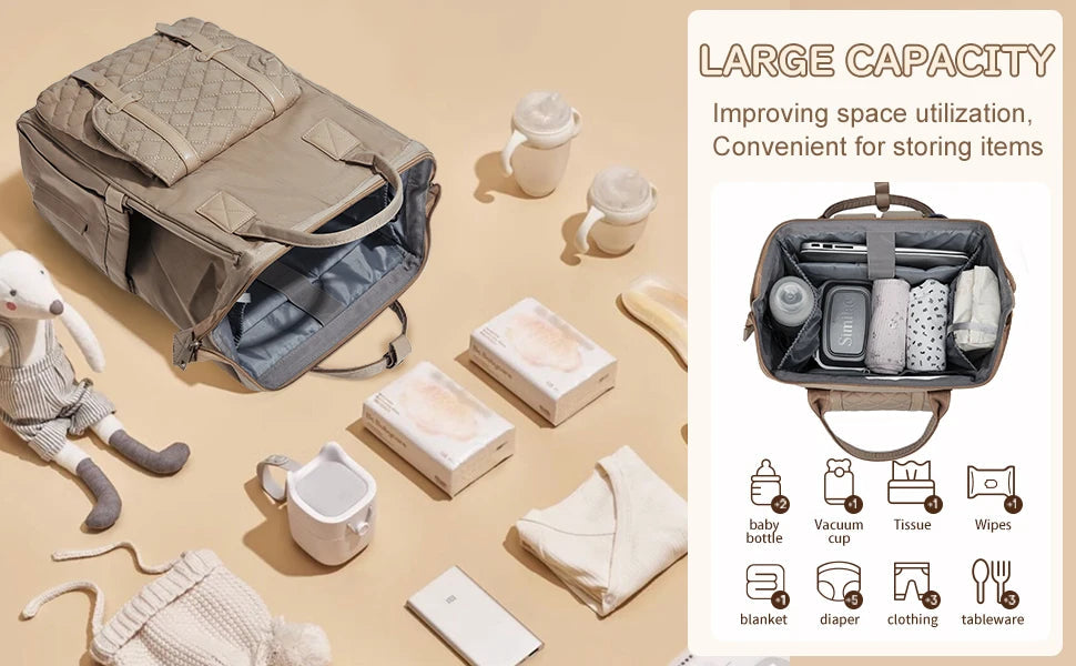 Sac a langer ouvert entoure de toutes les affaires de bebe rangees avec ordre, illustrant sa grande contenance et son organisation intelligente.