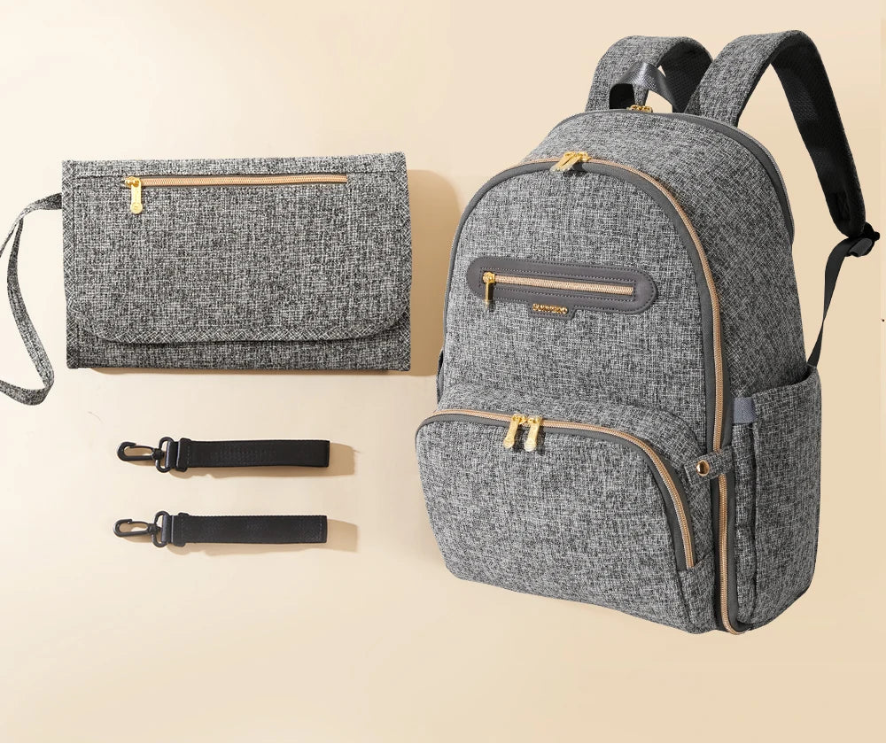 Sac a langer a dos gris chine avec matelas a langer assorti et deux sangles, un ensemble pret a l'emploi pour les sorties.