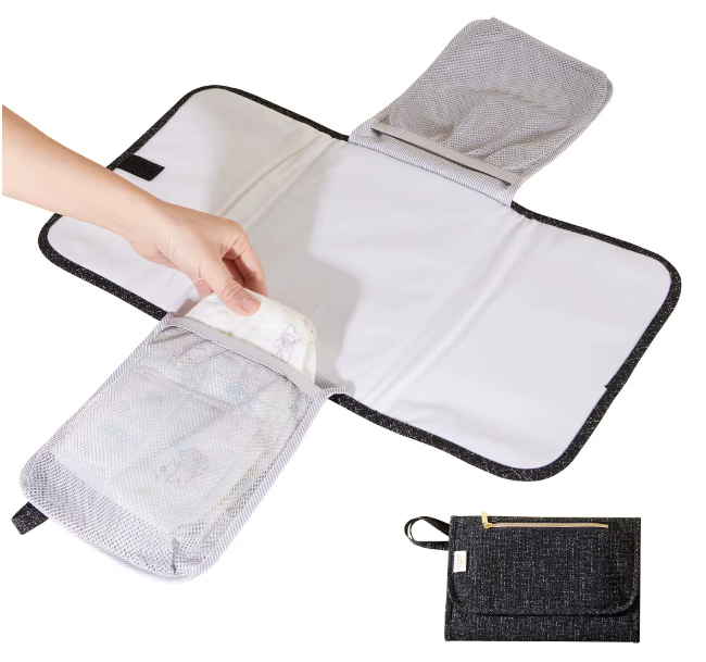 Tapis a langer nomade deplie avec poches en filet pour changer bebe partout et le ranger compact une fois plie.