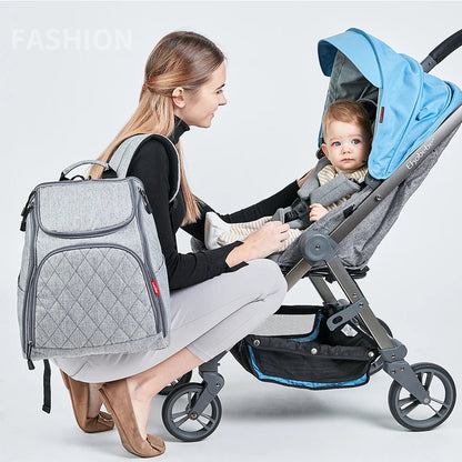 Maman ajustant son bebe en poussette avec le sac a langer sur le dos, ideal pour les promenades en ville.