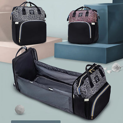 Sac a langer disponible en plusieurs coloris leopard avec lit bebe pliable deja deplie pour montrer sa transformation.