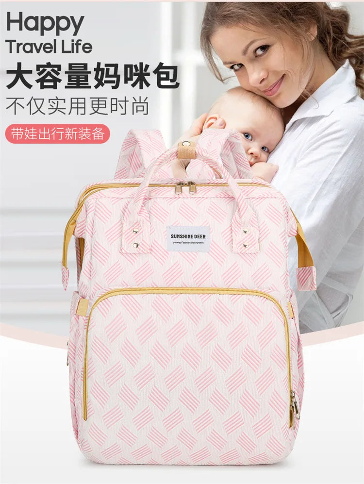 Maman avec son bebe et le sac a langer rose grande capacite, allie ideal des sorties en famille.
