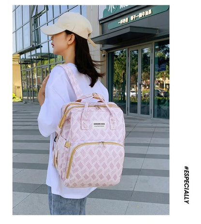 Le sac a langer porte sur une epaule, pratique et discret pour un usage quotidien en ville.