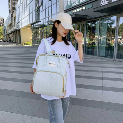 Jeune maman portant le sac a langer a la main en ville, un accessoire elegant et pratique au quotidien.