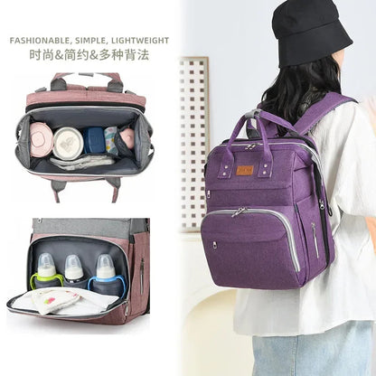 Maman portant le sac a langer en mode sac a dos, avec vue sur les compartiments interieurs bien organises.