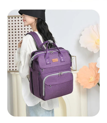 Sac a langer violet porte sur le dos, associant style et praticite pour les balades avec bebe.