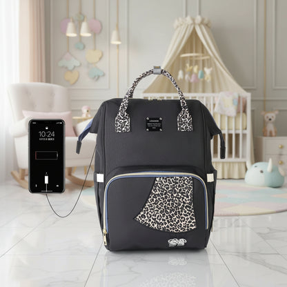 Sac a langer motif leopard camel avec fonction de recharge USB, melant esthetique tendance et fonctionnalite pratique.