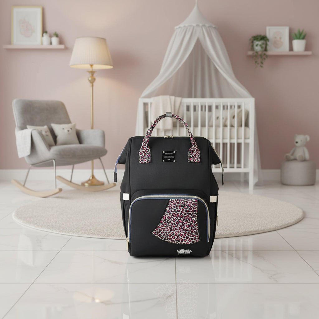 Sac a langer leopard aux touches rose fuchsia avec cable USB integre, pour un style affirme lors des sorties avec bebe.