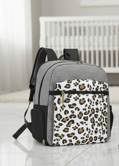 Presentation complete du sac a langer leopard montrant ses trois faces et son grand compartiment organise pour le materiel de bebe.