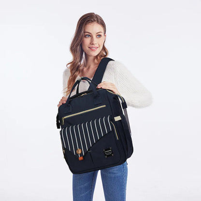 Maman tenant le sac a langer bleu marine par les poignees, un modele chic adapte aux parents actifs.