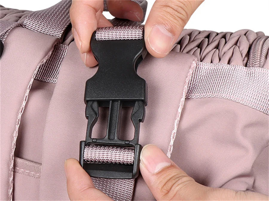 Gros plan sur la boucle a clip du sac a langer rose qui se ferme et s'ouvre facilement d'une seule main.